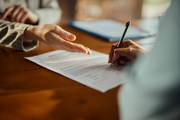 Una persona está escribiendo en un documento