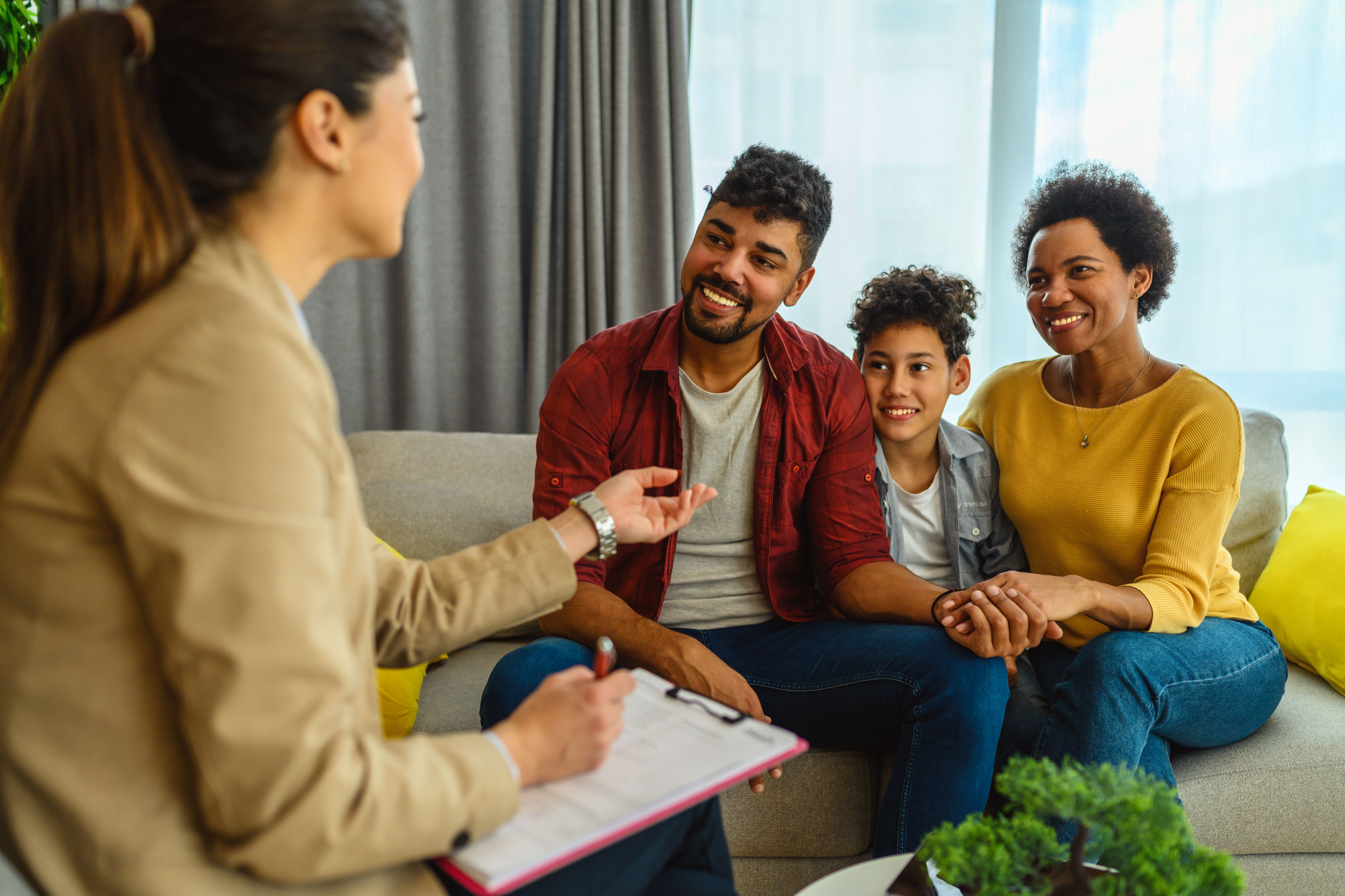 A photo of a family sitting on the couch and discussing eligibility updates.