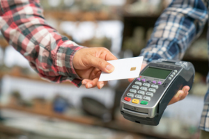 A customer tapping a chip card on a card reader.
