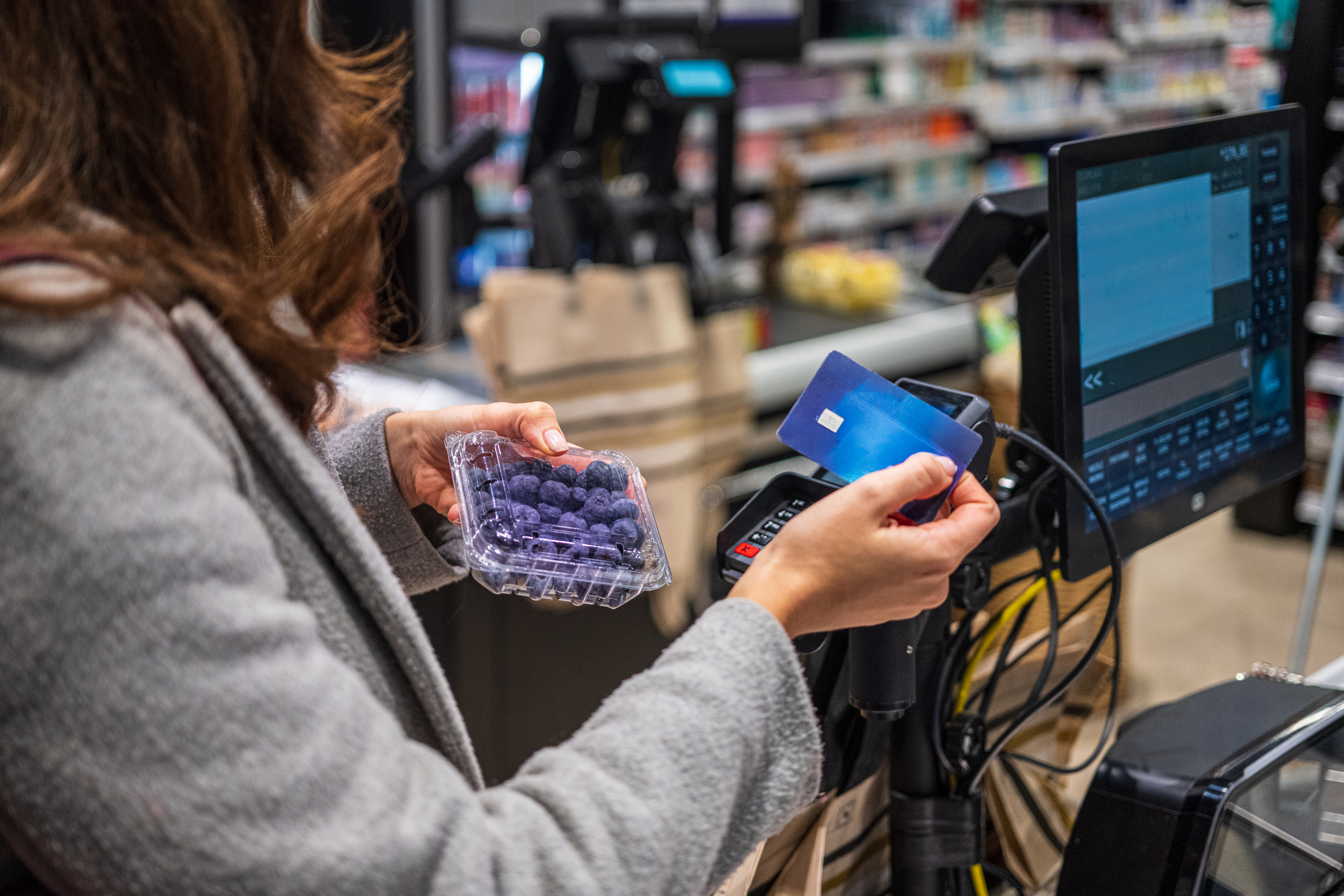A customer uses a blue chip card at a grocery store.