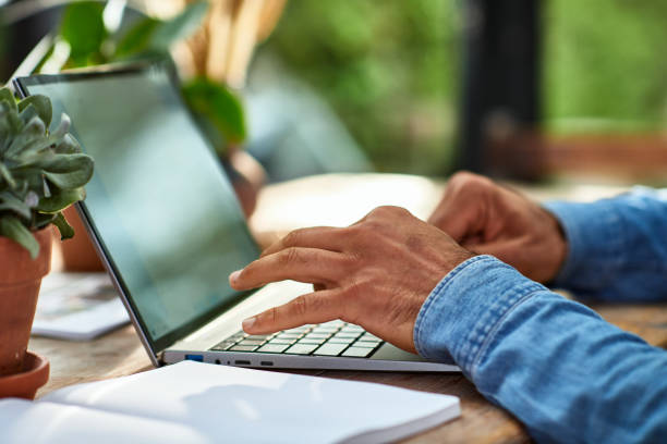 Una persona está escribiendo en el teclado de un portátil
